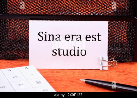 Sina era il più grande studio significa senza rabbia e dipendenza su un biglietto da visita bianco pulito accanto a una calcolatrice, una penna su sfondo arancione Foto Stock