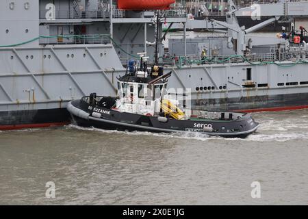 Il rimorchiatore del porto Serco SD SUZANNE spinge duramente sul lato del porto di DILIGENZA, mentre l'ex nave RFA viene trainata fuori dal porto in condizioni di vento Foto Stock