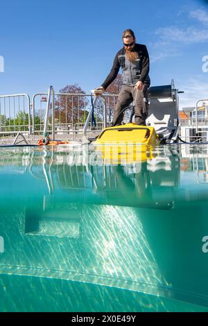 Erfurt, Germania. 11 aprile 2024. Carsten Bienert, il Bäder responsabile dello stabilimento SWE di Nordbad di Erfurt, pulisce una piscina con un aspirapolvere subacqueo durante i preparativi per la stagione al Nordbad di Erfurt. Crediti: Jacob Schröter/dpa/Alamy Live News Foto Stock
