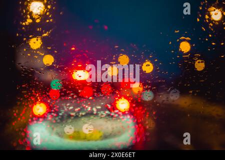 Guarda attraverso il parabrezza di un'auto di notte nel traffico e in caso di pioggia intensa Foto Stock