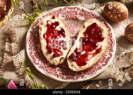 Due fette di dolce dolce pasquale ceco tradizionale chiamato mazanec con marmellata di burro e mirtilli rossi Foto Stock