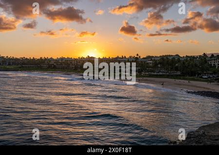 Il sole tramonta su Shipwreck Beach e il Grand Hyatt Kauai Resort and Spa sull'isola di Kauai, Hawaii, Stati Uniti. Foto Stock