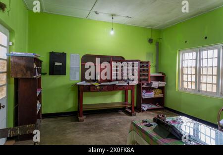 Stazione di Ambewela, Sri Lanka - 28 gennaio 2024: Ufficio pittoresco con mobili in legno, parete verde, illuminato da una lampada e da una finestra. Foto Stock