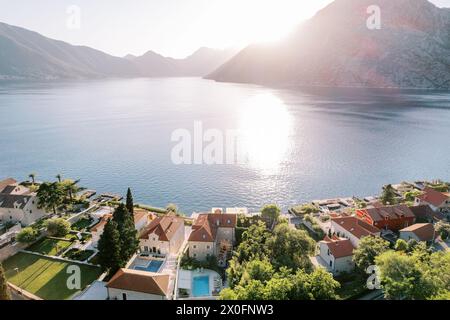 Piscine nei cortili di vecchie case con tetti rossi sulle rive della Baia di Cattaro. Orahovac, Montenegro. Drone Foto Stock