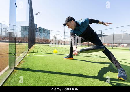 uomo che gioca a paddle tennis al coperto Foto Stock