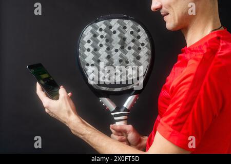 uomo con racchetta paddel e smartphone Foto Stock