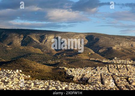 Maestoso tramonto con meravigliose nuvole sul Monte Hymettus e sulla città di Atene, Grecia. Ci sono diversi quartieri inclusi come Ilioupoli e Kesariani. Foto Stock