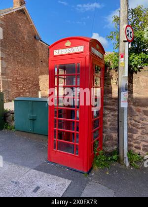 Un classico chiosco telefonico rosso britannico K2 riutilizzato come scambio di semi nel liceo vescovile vicino a taunton somerset inghilterra Regno Unito Foto Stock