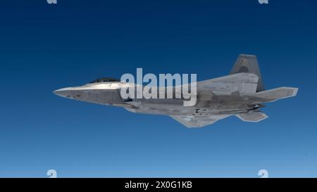 Un F-22A Raptor assegnato al 19th Fighter Squadron, Joint base Pearl Harbor–Hickam, Hawaii, vola accanto al 909th Air Refueling Squadron KC-135 S. Foto Stock