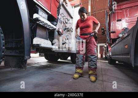 Vigile del fuoco che indossa una tuta antincendio contro il motore antincendio Foto Stock