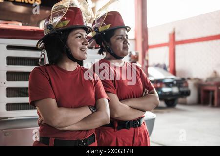 Ritratto di donna sorridente pompiere in piedi alla caserma dei pompieri Foto Stock