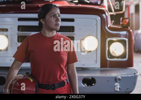 Ritratto di donna vigile del fuoco in piedi alla caserma dei pompieri Foto Stock