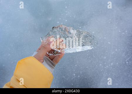 Donna che tiene il ghiaccio - Iceberg Frozen Lagoon Islanda - Winter Gear Cold Foto Stock