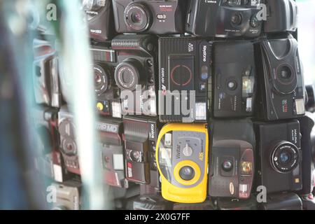 Vecchie telecamere a pellicola impilate e trasformate in una figura umana che mostra rifiuti elettronici o rifiuti elettronici che di solito vanno in discarica Foto Stock