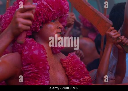 Munshiganj, Dacca, Bangladesh. 12 aprile 2024. I devoti indù hanno preso parte al festival annuale Lal Kach (vetro rosso) a Munshiganj, Bangladesh. Durante il festival Hindu Lal Kach, bambini e uomini si dipingono di colore rosso e partecipano a una processione con spade mentre mostrano il potere contro il male e accolgono il nuovo anno Bengalese. Il festival di Lal Kach è ben noto per la comunità locale da più di cento anni. Credito fotografico: ZUMA Press/Alamy Live News Foto Stock