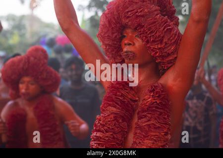 Munshiganj, Dacca, Bangladesh. 12 aprile 2024. I devoti indù hanno preso parte al festival annuale Lal Kach (vetro rosso) a Munshiganj, Bangladesh. Durante il festival Hindu Lal Kach, bambini e uomini si dipingono di colore rosso e partecipano a una processione con spade mentre mostrano il potere contro il male e accolgono il nuovo anno Bengalese. Il festival di Lal Kach è ben noto per la comunità locale da più di cento anni. Credito fotografico: ZUMA Press/Alamy Live News Foto Stock