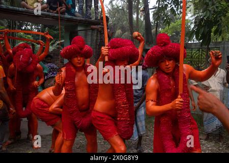 Munshiganj, Dacca, Bangladesh. 12 aprile 2024. I devoti indù hanno preso parte al festival annuale Lal Kach (vetro rosso) a Munshiganj, Bangladesh. Durante il festival Hindu Lal Kach, bambini e uomini si dipingono di colore rosso e partecipano a una processione con spade mentre mostrano il potere contro il male e accolgono il nuovo anno Bengalese. Il festival di Lal Kach è ben noto per la comunità locale da più di cento anni. Credito fotografico: ZUMA Press/Alamy Live News Foto Stock