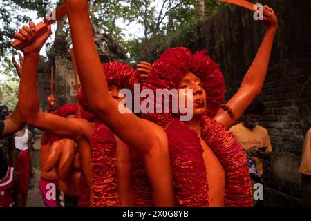 Munshiganj, Dacca, Bangladesh. 12 aprile 2024. I devoti indù hanno preso parte al festival annuale Lal Kach (vetro rosso) a Munshiganj, Bangladesh. Durante il festival Hindu Lal Kach, bambini e uomini si dipingono di colore rosso e partecipano a una processione con spade mentre mostrano il potere contro il male e accolgono il nuovo anno Bengalese. Il festival di Lal Kach è ben noto per la comunità locale da più di cento anni. Credito fotografico: ZUMA Press/Alamy Live News Foto Stock