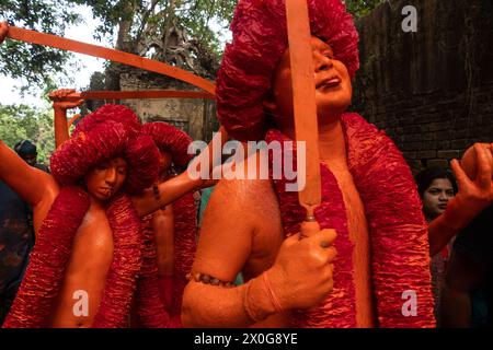 Munshiganj, Dacca, Bangladesh. 12 aprile 2024. I devoti indù hanno preso parte al festival annuale Lal Kach (vetro rosso) a Munshiganj, Bangladesh. Durante il festival Hindu Lal Kach, bambini e uomini si dipingono di colore rosso e partecipano a una processione con spade mentre mostrano il potere contro il male e accolgono il nuovo anno Bengalese. Il festival di Lal Kach è ben noto per la comunità locale da più di cento anni. Credito fotografico: ZUMA Press/Alamy Live News Foto Stock