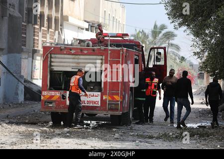 Un camion dei vigili del fuoco si schiude come fumo da un edificio dopo il bombardamento israeliano a Nuseirat Un camion dei vigili del fuoco schiera come fumo da un edificio dopo il bombardamento israeliano a Nuseirat, nel centro di Gaza, il 12 aprile 2024, nel mezzo delle continue battaglie tra Israele e il gruppo militante palestinese Hamas. Le autorità del territorio costiero palestinese governato da Hamas il 12 aprile hanno riferito decine di nuovi attacchi aerei nella regione centrale di Gaza. Foto di Naaman Omar apaimages Nusairat Striscia di Gaza territorio palestinese 120424 Nusairt Naa 1 007 Copyright: XapaimagesxNaamanxOmarxxxapaimagesx Foto Stock