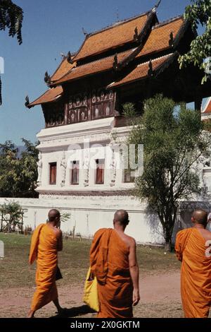 Tre monaci buddisti di fronte alla biblioteca Vihara nel complesso tempiale Wat Phra Singh. [traduzione automatica] Foto Stock