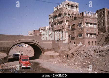 Auto utilizzare un wadi (essiccato fuori il letto del fiume) come una strada principale in Sanaa. Foto Stock