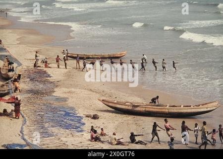 Gli uomini tirando reti da pesca a terra in Accra. Foto Stock