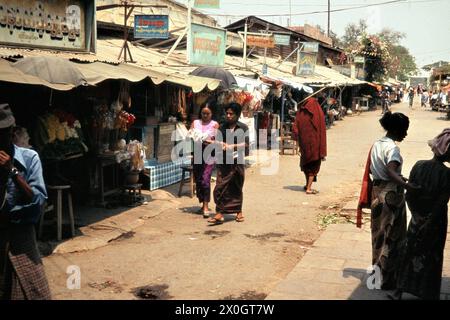 La gente passa i negozi in una strada commerciale sul terreno pagoda a Mandalay. [traduzione automatica] Foto Stock