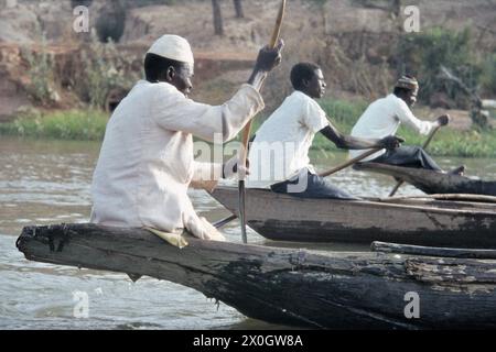 Uomini che guidano pirogues barche sul Niger vicino Niamey. [traduzione automatica] Foto Stock