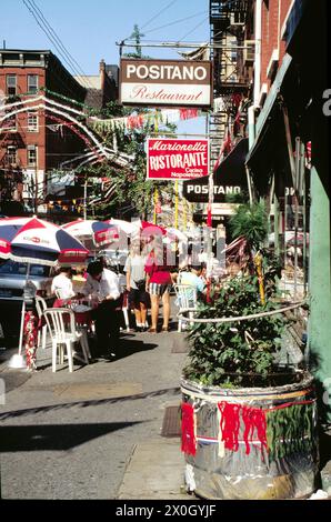 Scene di strada a Little Italy a New York con molte persone sulla strada di fronte ai caffè. [traduzione automatica] Foto Stock