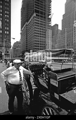 Un autista in attesa di passeggeri accanto al suo carro di fronte ad un edificio a Central Park. Foto Stock