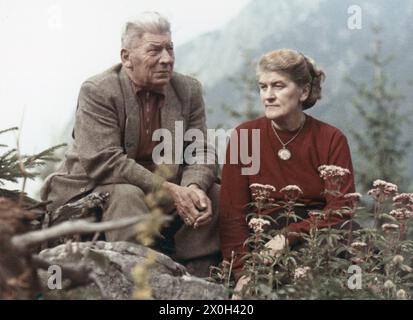 Una coppia anziana è seduta in un prato in montagna. [traduzione automatica] Foto Stock