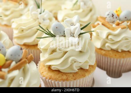 Gustosi cupcake pasquali con panna alla vaniglia in scatola, primo piano Foto Stock