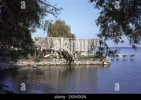 Le reti da pesca sono appese su scaffali di legno per asciugarsi sulla riva del lago Chiemsee. [traduzione automatizzata] Foto Stock