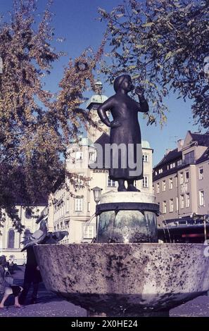 Vista della fontana Liesl Karlstadt della famosa attrice al Viktualienmarkt di Monaco. La Chiesa dello Spirito Santo può essere vista sullo sfondo. [traduzione automatizzata] Foto Stock
