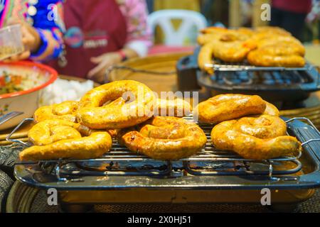 Viziatevi con i sapori della Thailandia settentrionale con questa saporita delizia! Salsicce aromatiche alla griglia, rinomate per la loro miscela unica di spezie e ricche fl Foto Stock