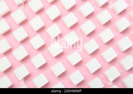 Cubetti di zucchero bianchi su sfondo rosa, vista dall'alto Foto Stock