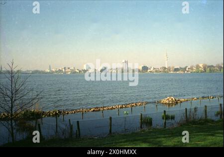 Vista dalle rive dell'Alster sull'Alster, la torre della televisione e lo skyline di Amburgo, all'estrema sinistra il ponte che collega l'Alster interno ai Longobardi dell'Alster esterno, i ponti ferroviari e Kennedy [traduzione automatica] Foto Stock