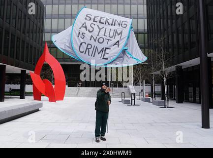 Pit Sami Kupiszewski, che attualmente si rifugia in una tenda all'esterno dell'Ufficio internazionale di protezione su Mount Street, tiene in alto una tenda presso il Dipartimento di integrazione di Dublino. Un gruppo di attivisti è stato affiancato dal TDS presso il Dipartimento dell'integrazione per presentare una lettera in cui si chiedeva che il Ministero per i bambini, l'uguaglianza, la disabilità, l'integrazione e la gioventù, il dipartimento di Roderic o'Gorman adottasse un approccio più umano, proattivo, efficace ed equo alla questione dell'alloggio dei rifugiati. Data foto: Venerdì 12 aprile 2024. Foto Stock