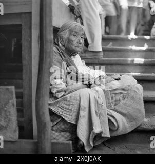 Una vecchia donna a Cuernavaca in Messico è seduta su una scala. Ha un cestino con lei. [traduzione automatica] Foto Stock