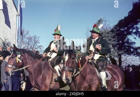 Due piloti in costume tradizionale con cappelli e berretti al Tölzer Leonhardi Ride il 6 novembre. Sullo sfondo potete vedere gli spettatori. Foto non datata, metà degli anni '60. [traduzione automatica] Foto Stock