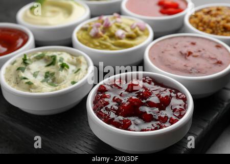 Diverse salse gustose in ciotole sul tavolo, primo piano Foto Stock