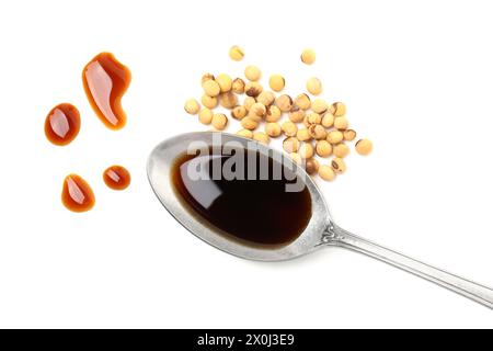 Gustosa salsa di soia in cucchiaio e soia isolata sul bianco, vista dall'alto Foto Stock