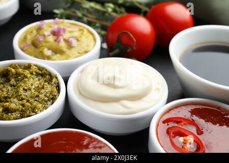 Diverse salse gustose in ciotole sul tavolo, primo piano Foto Stock