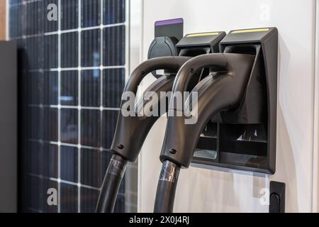 Primo piano della stazione di ricarica per auto elettriche sullo sfondo dei pannelli solari. Foto Stock