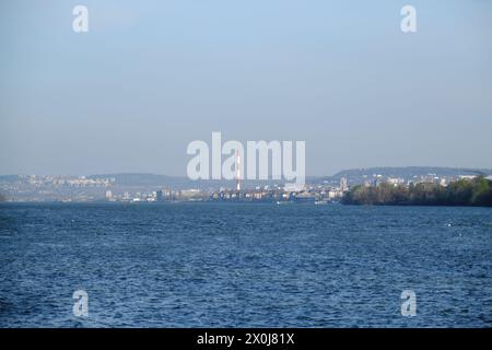 Vista panoramica di Belgrado a distanza dal quartiere di Zemun. L'ampio fiume Danubio in primo piano nelle giornate di sole primaverili Foto Stock