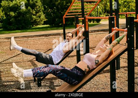 Un uomo e una donna in abbigliamento sportivo si stendono su una panchina all'aperto, facendo una pausa dopo l'esercizio fisico con un programma personale. Foto Stock