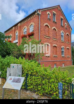 Un cartello informativo in primo piano descrive la storia della vecchia farmacia nella località di villeggiatura e nella località balneare baltica di Prerow, Fischland Darß, Meclemburgo-Vorpommern, Germania Foto Stock