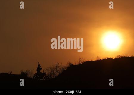 Ultimo tramonto dell'anno nepalese 2080 BS Bikers cavalcando sullo sfondo dell'ultimo tramonto del sole nepalese anno 2080 BS Bikram Sambat secondo il calendario georgiano nella periferia di Kathmandu il 12 aprile 2024. Nepal il 13 aprile 2024 festeggia il nuovo anno 2081 BS con grandeur e fervore. Copyright: XSubashxShresthax Foto Stock