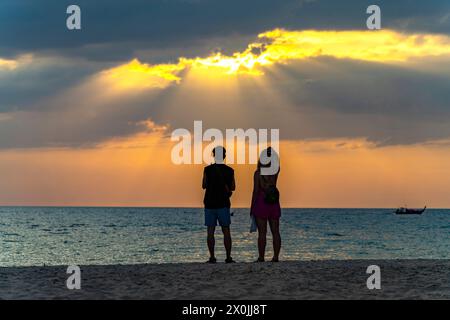 Coppia al tramonto a Farang o Charlie Beach sull'isola di Koh Mook nel Mare delle Andamane, Thailandia, Asia Foto Stock